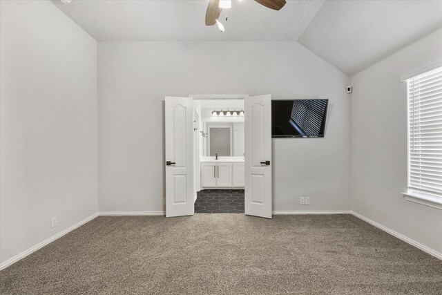 unfurnished room featuring ceiling fan, vaulted ceiling, and carpet flooring