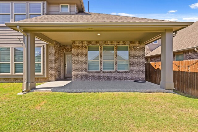 back of house with a lawn and a patio