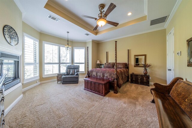 carpeted bedroom featuring ceiling fan, crown molding, and a tray ceiling