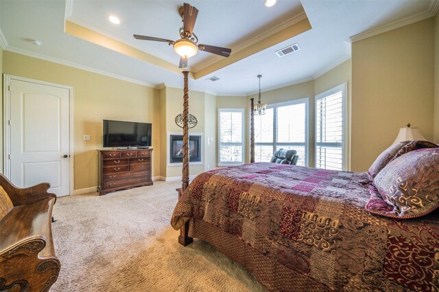 bedroom featuring a tray ceiling, carpet floors, ceiling fan with notable chandelier, and ornamental molding