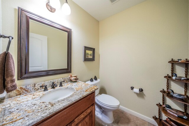 bathroom featuring tile patterned floors, toilet, and vanity