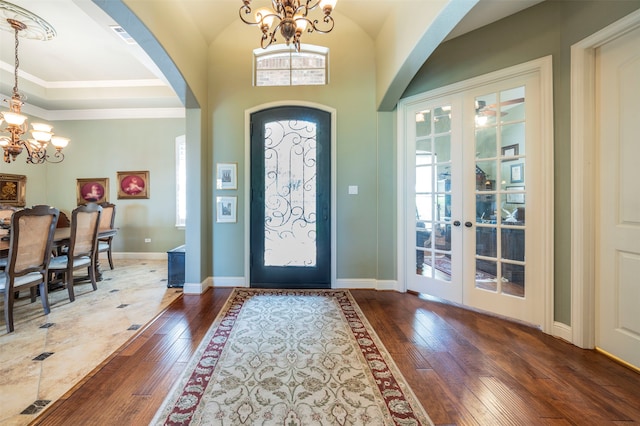 foyer featuring an inviting chandelier, hardwood / wood-style floors, and french doors