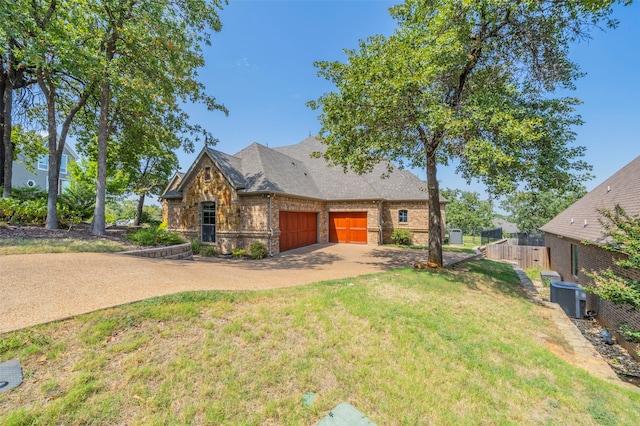 view of front of house with a garage, central air condition unit, and a front yard