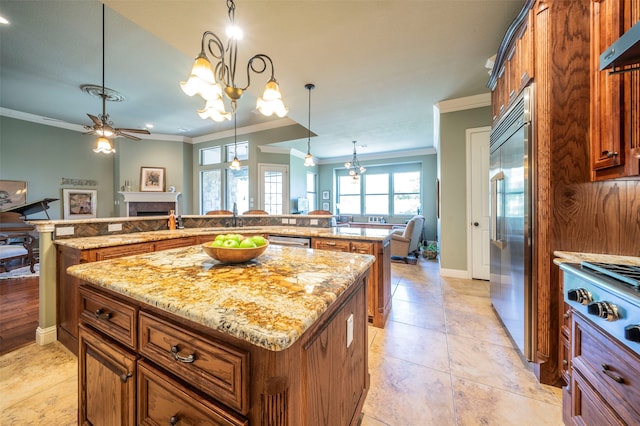 kitchen with ornamental molding, appliances with stainless steel finishes, a kitchen island, ceiling fan, and pendant lighting