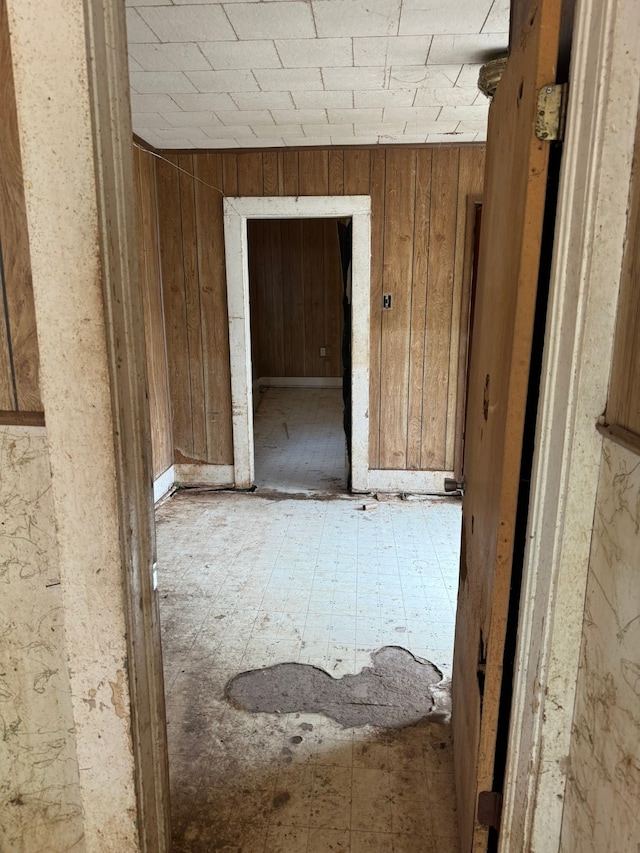 corridor featuring wood walls and tile patterned flooring