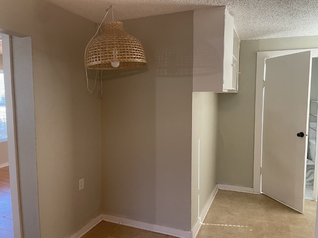 interior space featuring a textured ceiling and light tile patterned floors