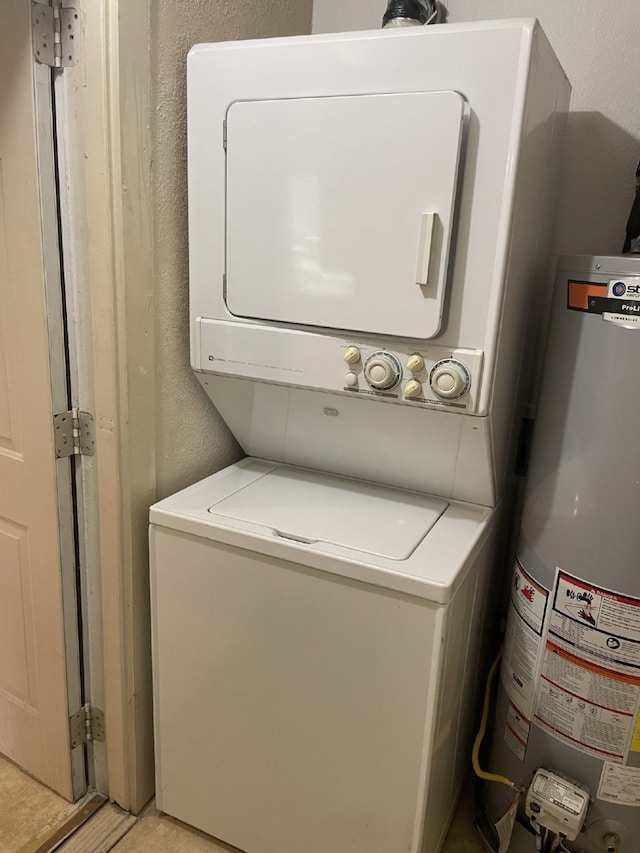 laundry area featuring water heater and stacked washer and clothes dryer