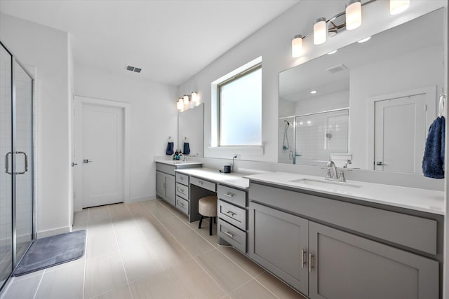 bathroom featuring a shower with door, vanity, and tile patterned flooring