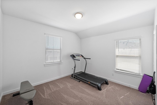 exercise room with vaulted ceiling and carpet floors