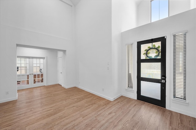 foyer entrance with light hardwood / wood-style flooring and a high ceiling