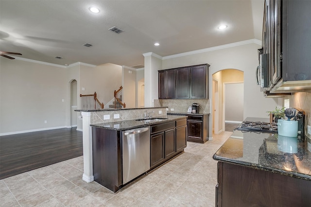 kitchen featuring dishwasher, light hardwood / wood-style flooring, crown molding, dark stone counters, and ceiling fan