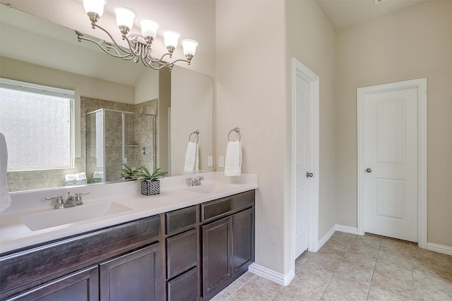 bathroom with a shower with door, tile patterned floors, vanity, and an inviting chandelier