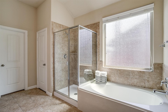 bathroom with tile patterned flooring, independent shower and bath, and vaulted ceiling