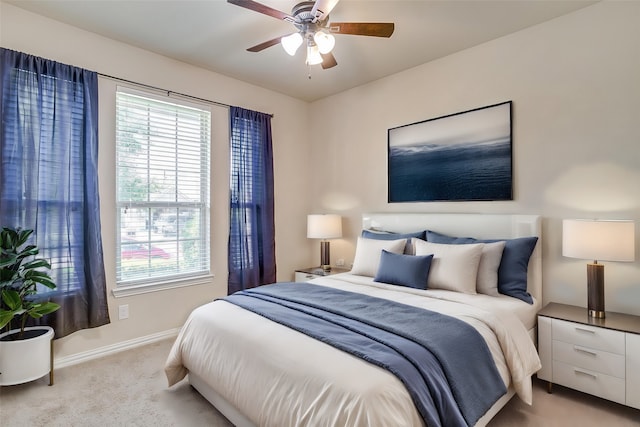 carpeted bedroom featuring ceiling fan and multiple windows