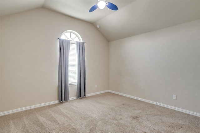 carpeted spare room featuring a wealth of natural light, ceiling fan, and lofted ceiling