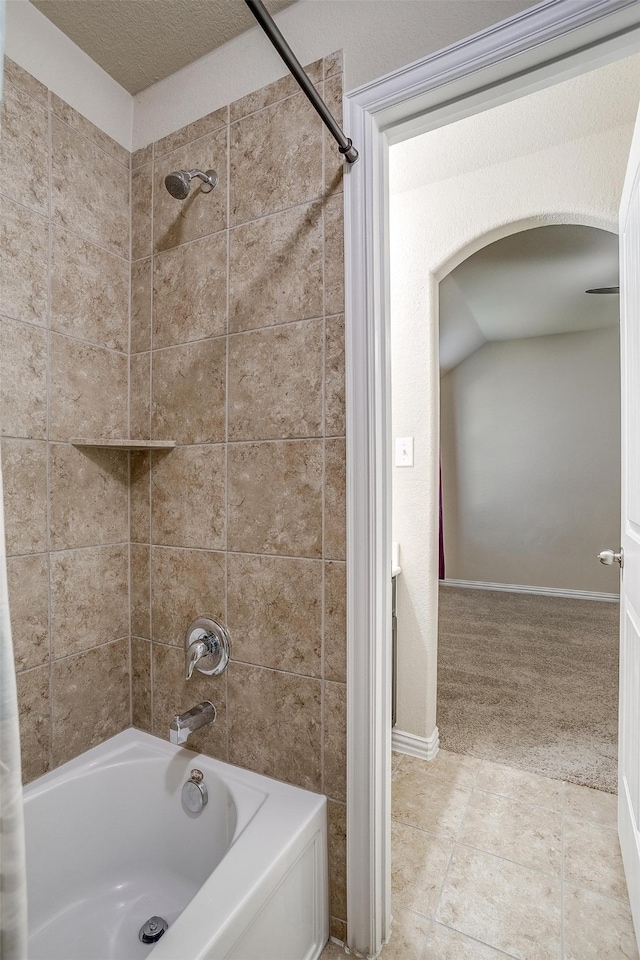 bathroom featuring tiled shower / bath, a textured ceiling, and tile patterned floors