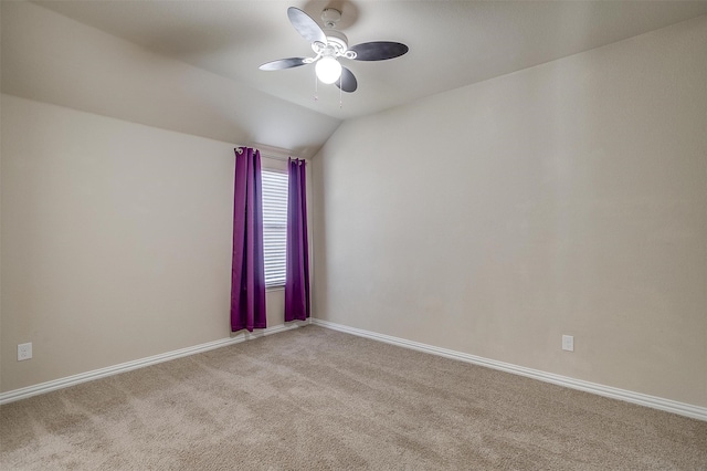 carpeted spare room featuring ceiling fan and vaulted ceiling