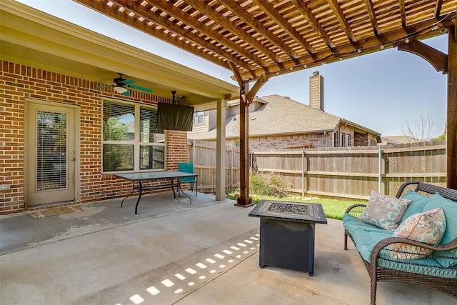 view of patio / terrace with ceiling fan, an outdoor living space with a fire pit, and a pergola