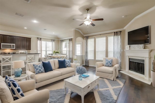 living room featuring ceiling fan, crown molding, vaulted ceiling, and wood-type flooring