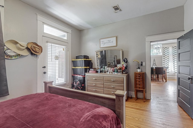 bedroom featuring light wood-style floors and visible vents