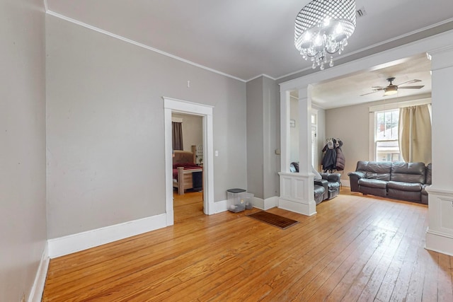 interior space featuring light hardwood / wood-style floors, ceiling fan with notable chandelier, and crown molding