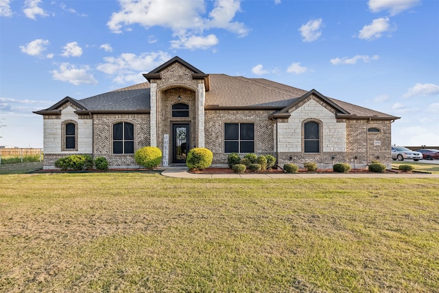 french country home featuring a front lawn