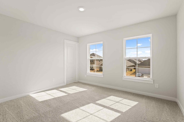 unfurnished room featuring a wealth of natural light and light colored carpet