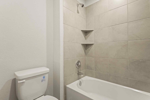 bathroom featuring toilet and tiled shower / bath