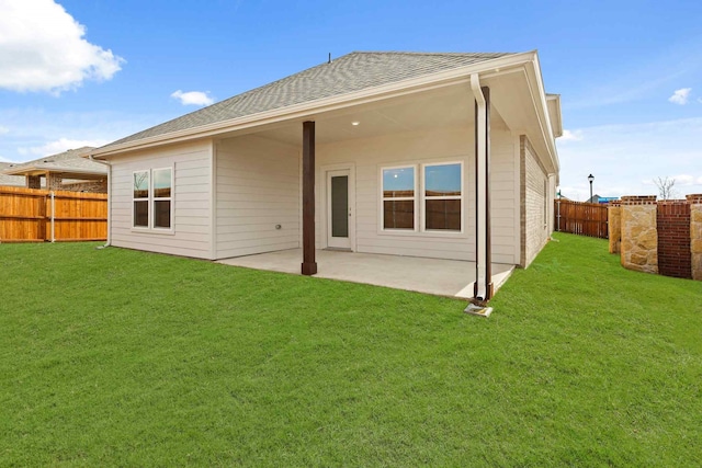 back of house featuring a lawn and a patio area