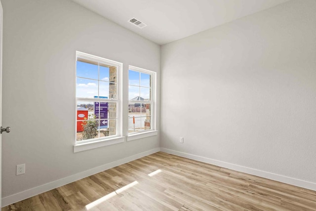 empty room featuring plenty of natural light and light hardwood / wood-style flooring