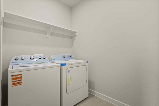 laundry room featuring washing machine and dryer and light tile patterned floors