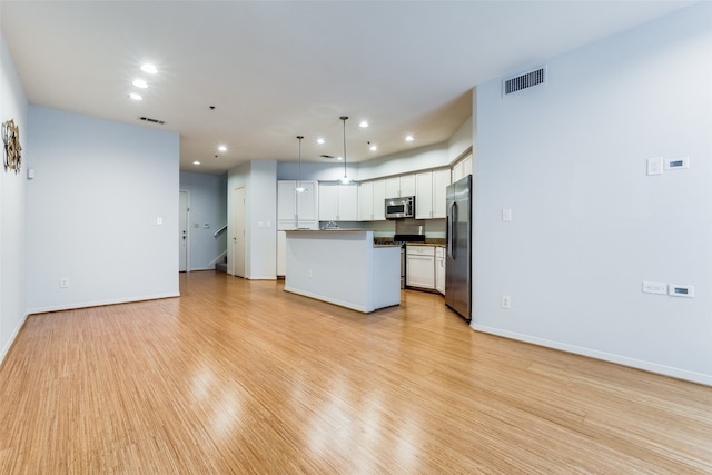 kitchen with a center island, light hardwood / wood-style floors, white cabinetry, appliances with stainless steel finishes, and decorative light fixtures