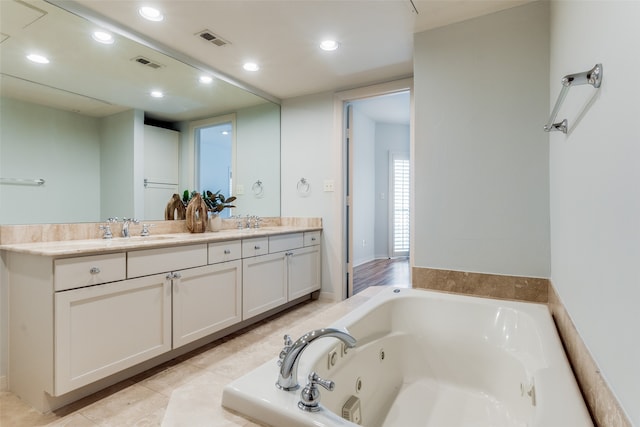 bathroom with vanity, tile patterned floors, and a tub