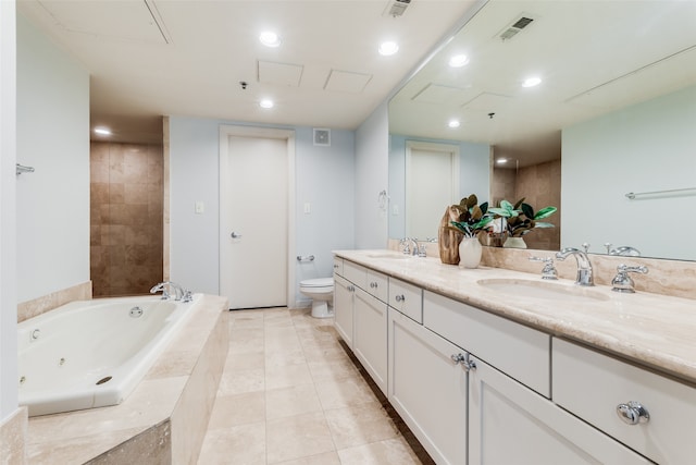 bathroom featuring tiled bath, tile patterned floors, vanity, and toilet