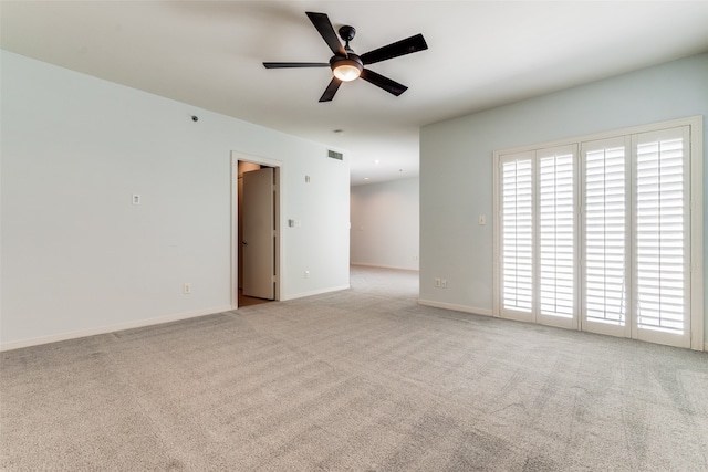 carpeted spare room with ceiling fan