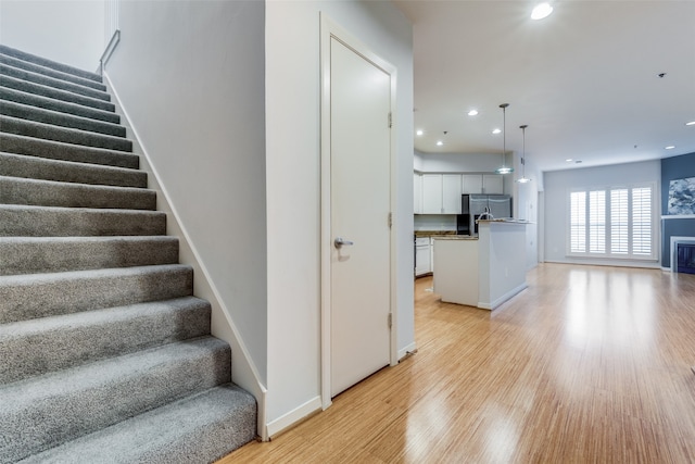 stairs featuring hardwood / wood-style floors