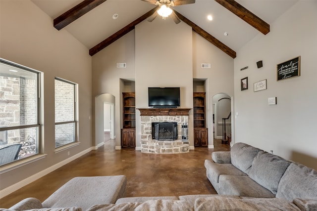 living room with a stone fireplace, ceiling fan, high vaulted ceiling, and beamed ceiling