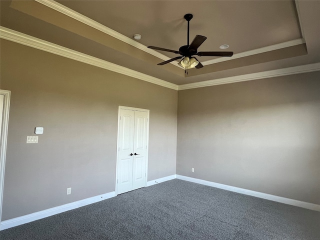 carpeted empty room featuring ornamental molding, a raised ceiling, and ceiling fan