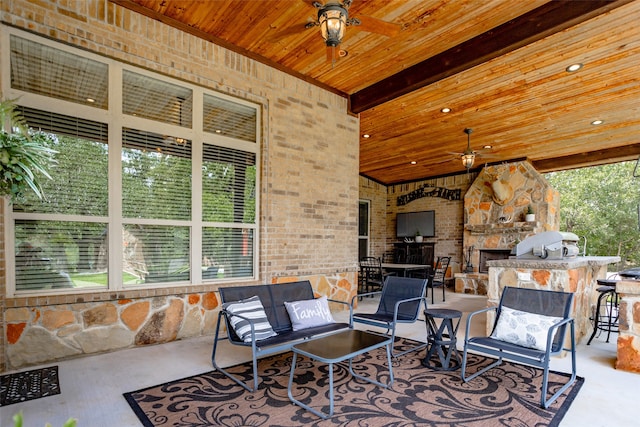 view of patio with ceiling fan, area for grilling, and exterior bar