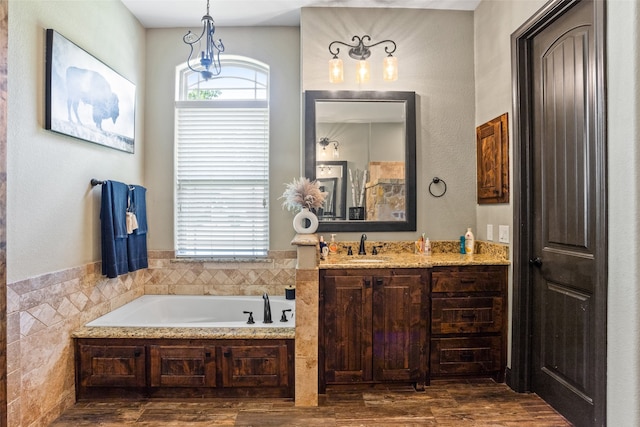 bathroom with a bathtub, vanity, and wood-type flooring