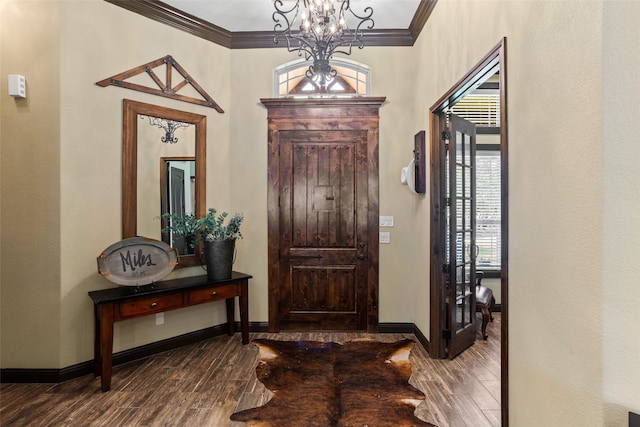 foyer entrance with hardwood / wood-style floors, crown molding, and a notable chandelier