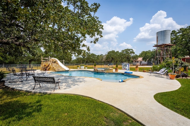 view of swimming pool with a patio, a water slide, and a yard