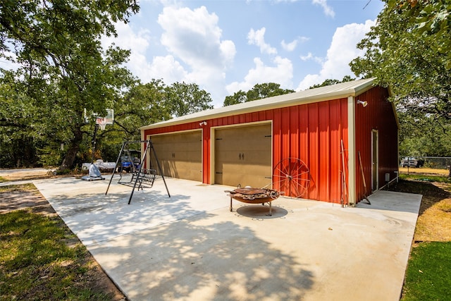 view of patio / terrace featuring an outdoor fire pit, an outdoor structure, and a garage