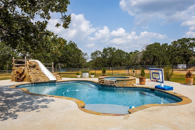 view of swimming pool with an in ground hot tub, a water slide, and pool water feature