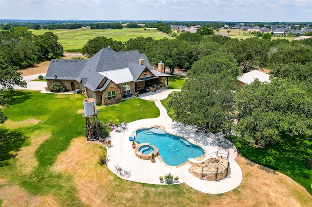 view of swimming pool featuring a rural view, a patio, and a lawn