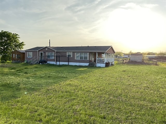 back house at dusk featuring a yard