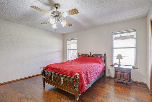 bedroom featuring ceiling fan, dark wood-type flooring, and a textured ceiling