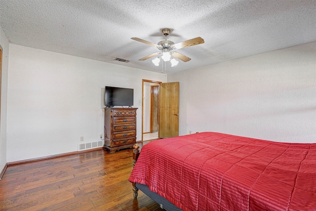 bedroom featuring ceiling fan, a textured ceiling, and wood-type flooring