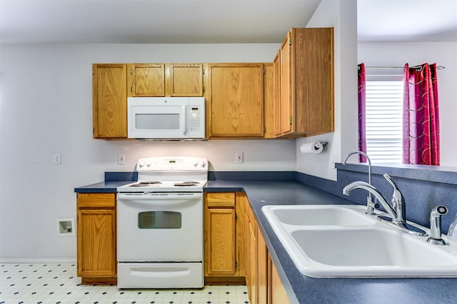 kitchen with white appliances, brown cabinetry, dark countertops, light floors, and a sink