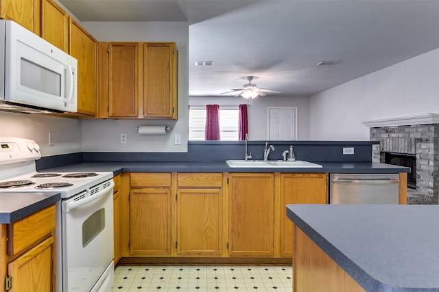 kitchen with light floors, dark countertops, visible vents, a sink, and white appliances